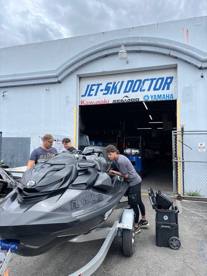 The team inspecting a Sea-Doo outside the shop